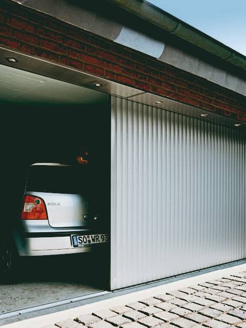 Sliding garage door running along the wall of a garage opening